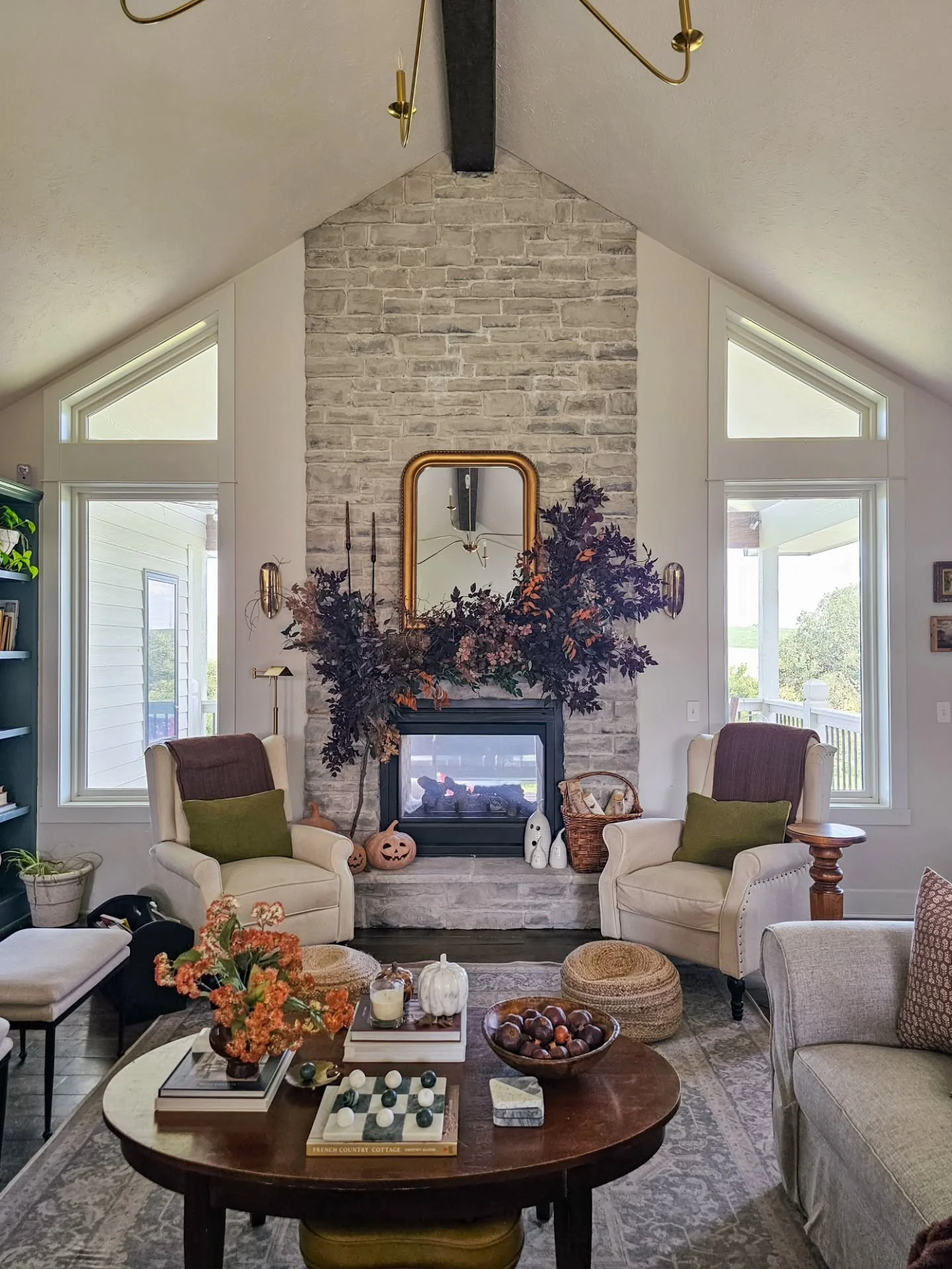 شومینه سنگی با اکسنت‌های پاییزی تیره در نشیمن